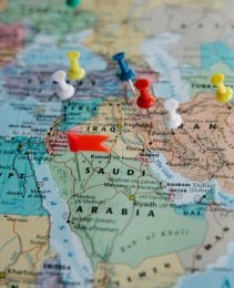 Colorful pushpins mark locations on a map of the Middle East, highlighting travel plans.